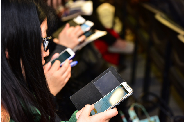 Teachers participating in real-time activities using mobile phones.