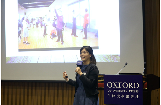 Ms Jenny Leung showing the audience a photo in which students were performing a freeze frame activity in her English class