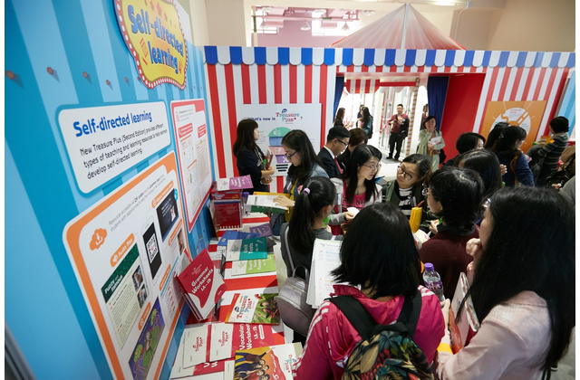 Teachers reading our new series New Treasure Plus (Second Edition) before the seminar