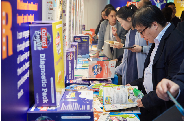 Teachers looking through Oxford English (Second Edition) before the seminar